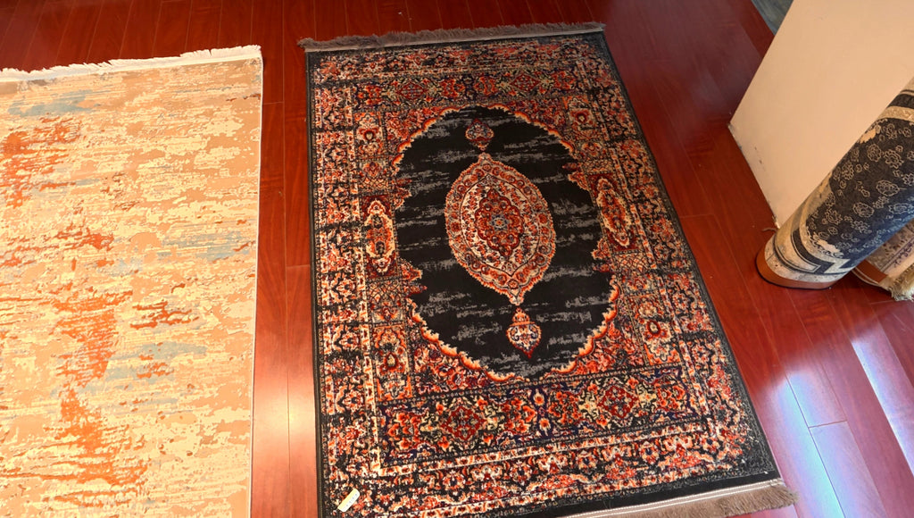 Decorative rug with intricate patterns on a wooden floor.