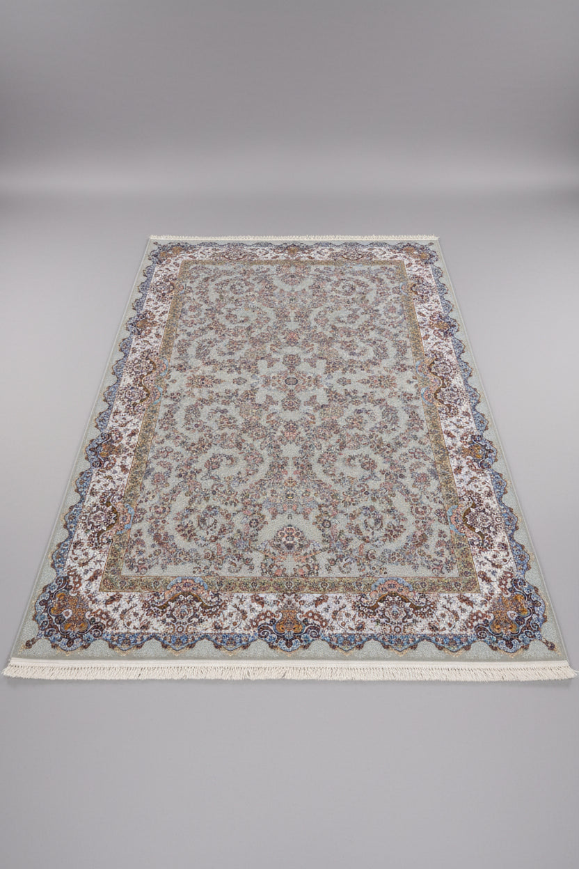 A large traditional Persian-style area rug with an intricate floral pattern, laid out on a wooden floor. The rug features a cream and beige base with blue, brown, and gold accents in its detailed motifs and border.